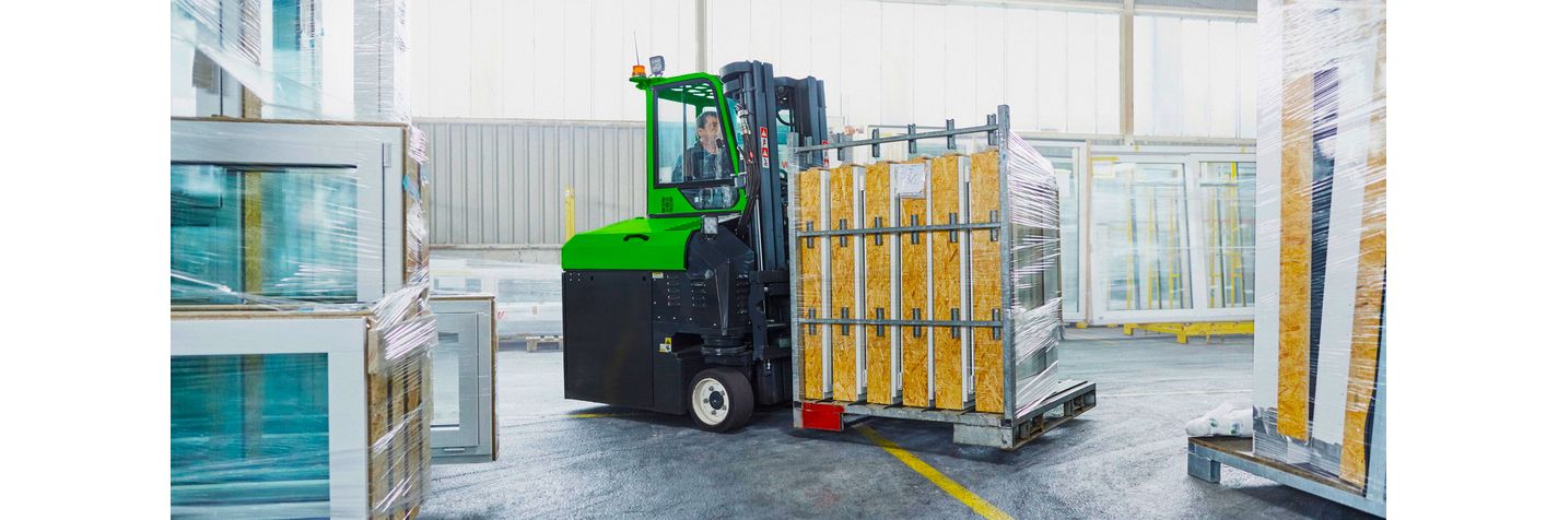 Combilift monitievastapainotrukki käsittelee ikkunaelementtejä varastossa