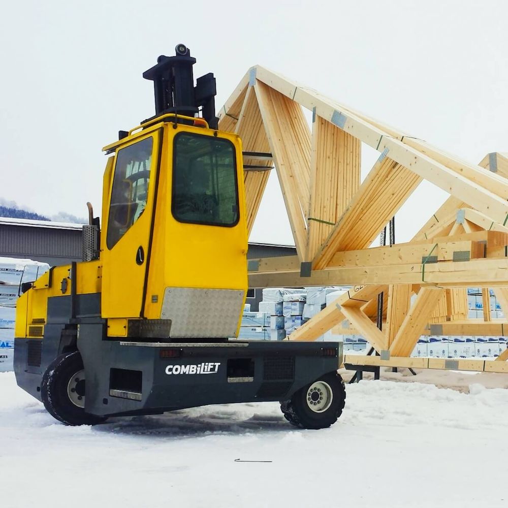 Nelitietrukki Combilift Combi-SL käsittelee kattotuoleja talvimaisemassa