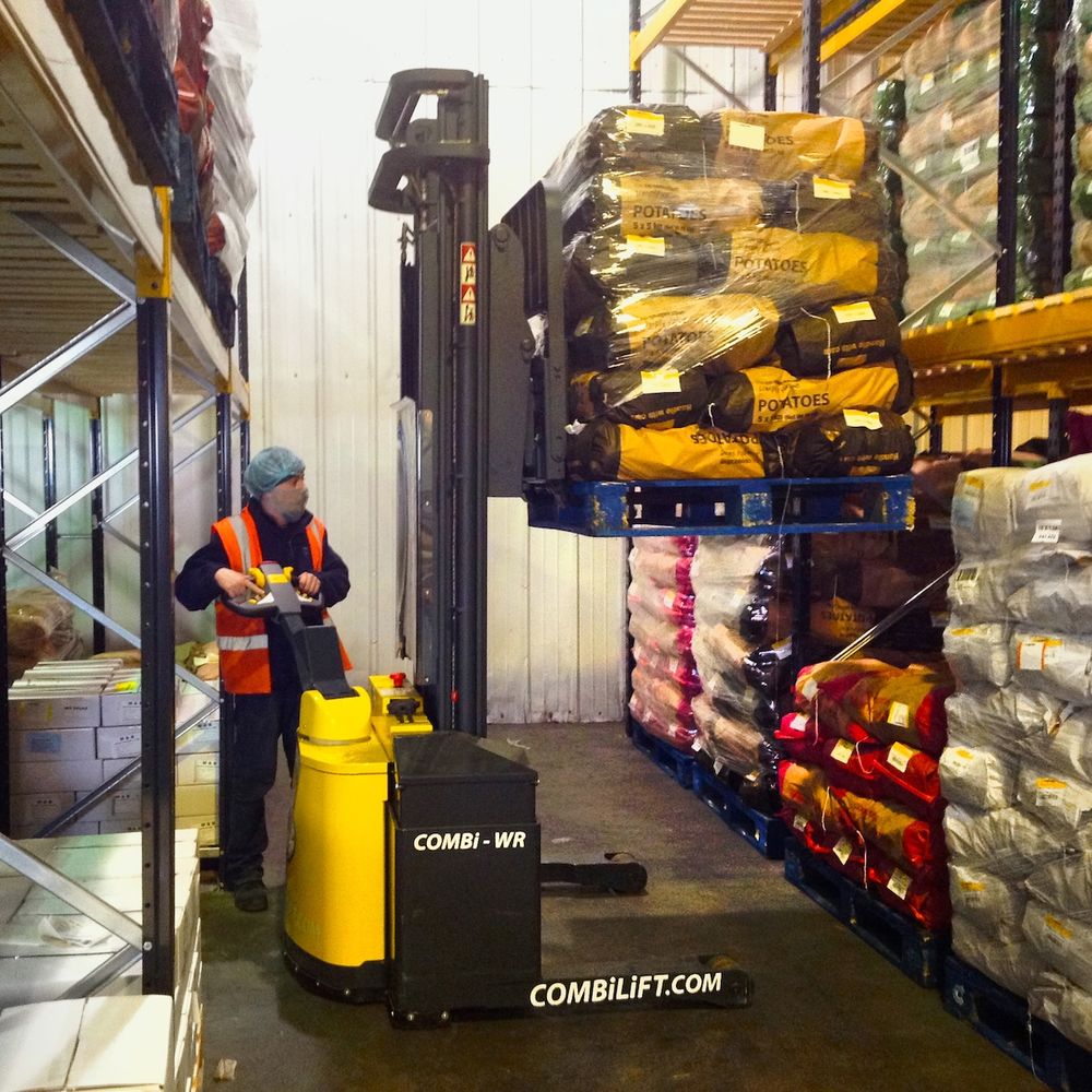 Pinoamisvaunu Combilift Combi-WR nostaa perunasäkkejä varastossa